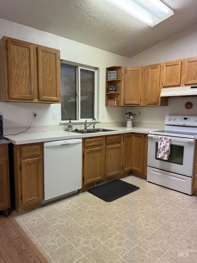 kitchen with white appliances, lofted ceiling, sink, and a textured ceiling