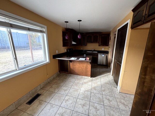 kitchen with sink, stainless steel dishwasher, kitchen peninsula, decorative light fixtures, and dark brown cabinets