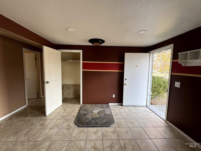 tiled entryway featuring a textured ceiling