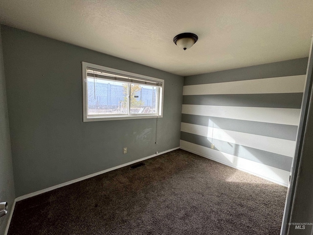 carpeted empty room with a textured ceiling