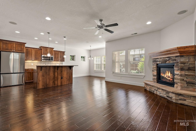 2174 S Myers Pl, Boise, ID 83706 - unfurnished living room with a ceiling fan, a fireplace, baseboards, recessed lighting, and a textured ceiling