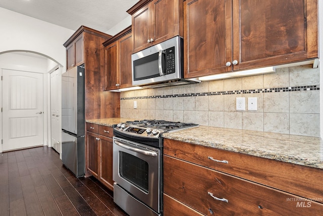 2174 S Myers Pl, Boise, ID 83706 - kitchen featuring stainless steel appliances, light stone counters, decorative backsplash, and dark wood-style floors