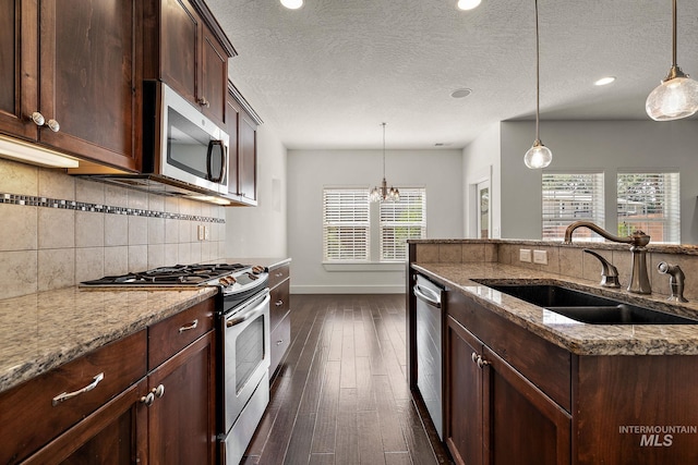 2174 S Myers Pl, Boise, ID 83706 - kitchen with stainless steel appliances, a sink, baseboards, decorative backsplash, and dark wood-type flooring