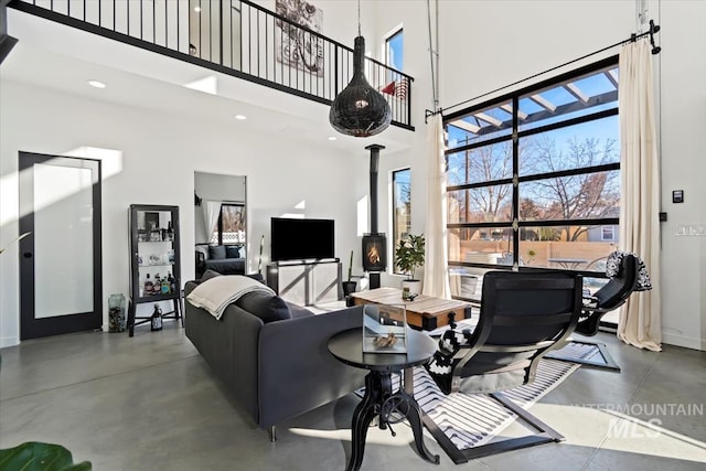 living room with a towering ceiling and a wood stove