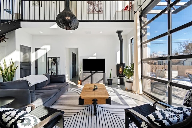 living room with a high ceiling and a wood stove