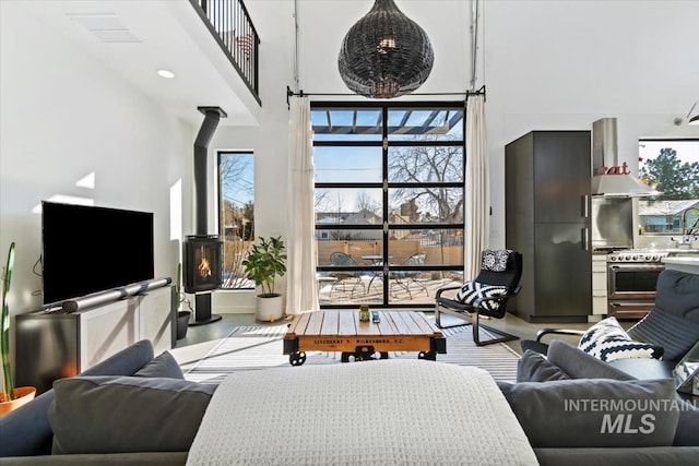 living room with a towering ceiling and a wood stove