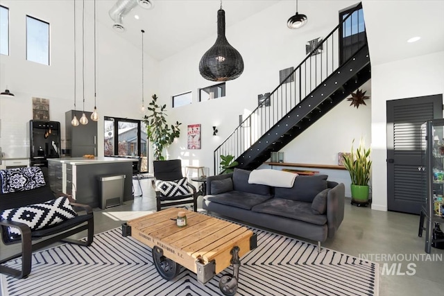living room featuring concrete flooring and a high ceiling