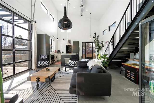 living room featuring a towering ceiling and concrete flooring
