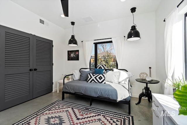 bedroom featuring concrete flooring and a closet