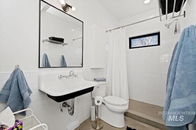 bathroom featuring toilet, sink, tile patterned floors, and walk in shower