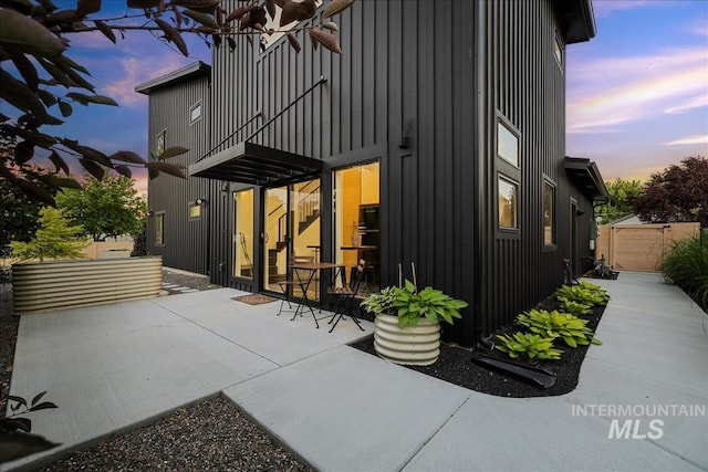 back house at dusk with a patio