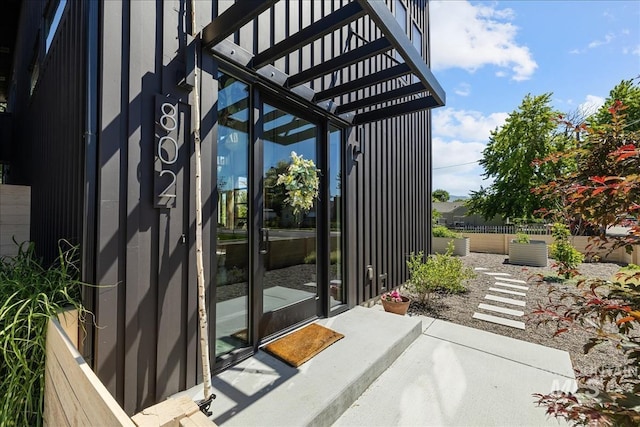 view of exterior entry featuring a pergola
