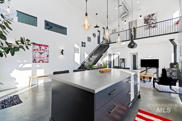 kitchen featuring a high ceiling, a kitchen island, and pendant lighting