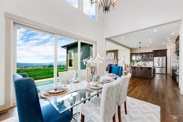 dining area with sink, hardwood / wood-style floors, and an inviting chandelier