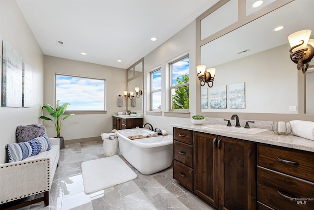 bathroom featuring a washtub, vanity, a chandelier, and tile patterned flooring