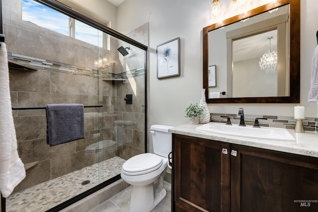 bathroom featuring toilet, a notable chandelier, tile patterned floors, walk in shower, and vanity