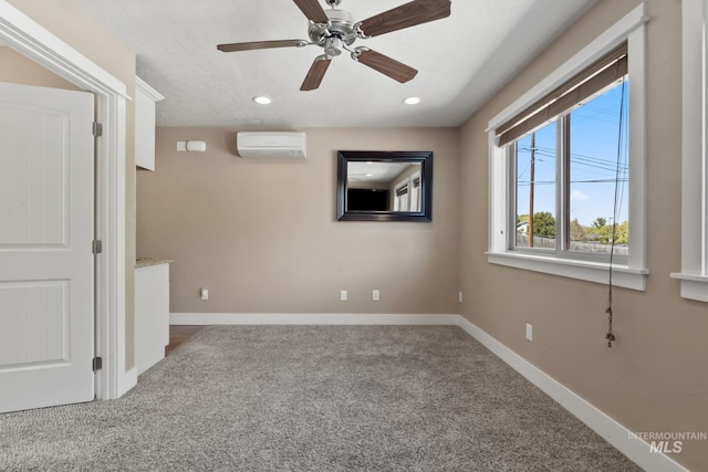 unfurnished room with recessed lighting, a wall mounted air conditioner, baseboards, and carpet