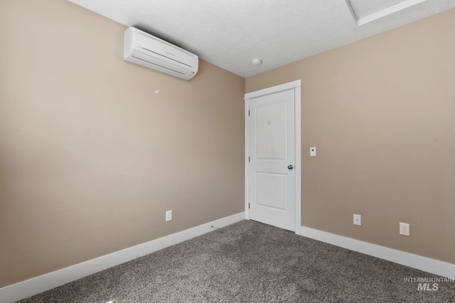 empty room with baseboards, dark colored carpet, and an AC wall unit