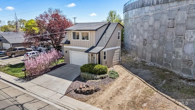 view of property exterior featuring driveway, roof with shingles, and a garage