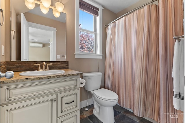 bathroom featuring vanity, a wall mounted AC, baseboards, toilet, and stone finish floor