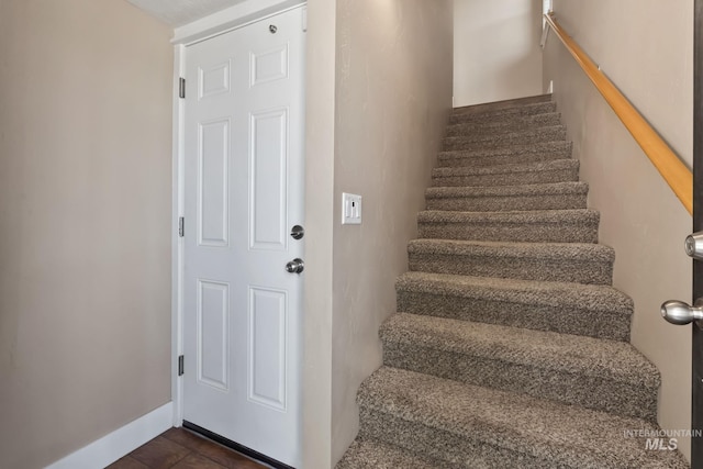 stairway featuring baseboards and tile patterned floors