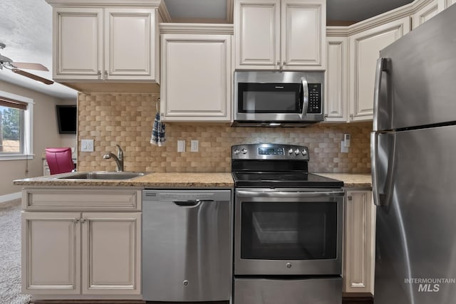 kitchen with backsplash, a ceiling fan, a sink, baseboards, and appliances with stainless steel finishes