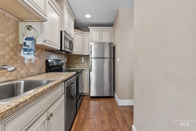 kitchen with baseboards, a sink, backsplash, and appliances with stainless steel finishes