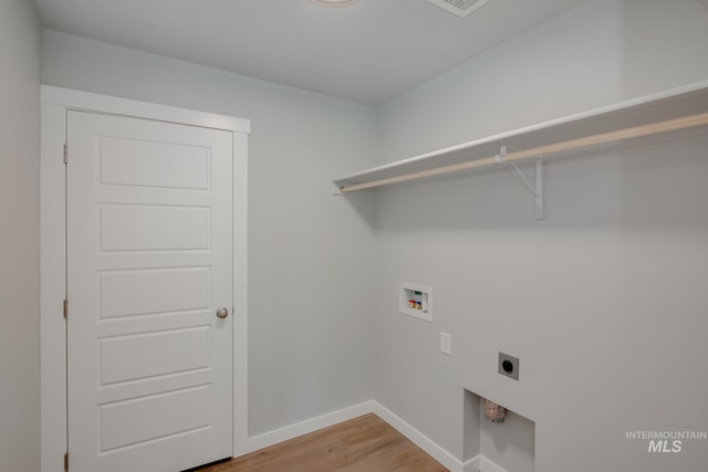 clothes washing area featuring washer hookup, wood-type flooring, and hookup for an electric dryer