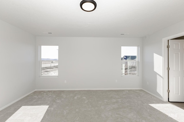 spare room featuring light carpet and a textured ceiling