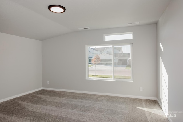 carpeted empty room with lofted ceiling