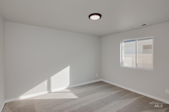 spare room featuring light colored carpet