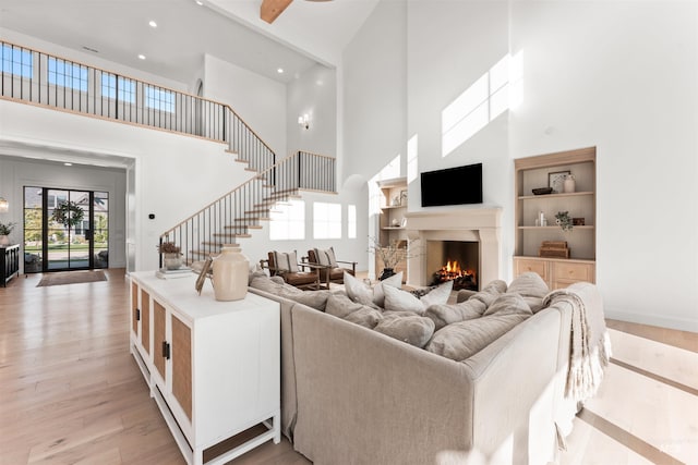 1734 S S Riparian Way, Eagle, ID 83616 - living room with a high ceiling, a lit fireplace, stairway, light wood-style floors, and recessed lighting