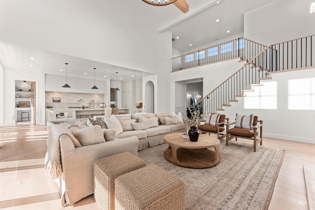 1734 S S Riparian Way, Eagle, ID 83616 - living area featuring light wood finished floors, stairs, recessed lighting, a high ceiling, and arched walkways