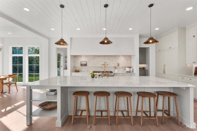 1734 S S Riparian Way, Eagle, ID 83616 - kitchen featuring light wood-style floors, recessed lighting, light stone countertops, tasteful backsplash, and wood ceiling
