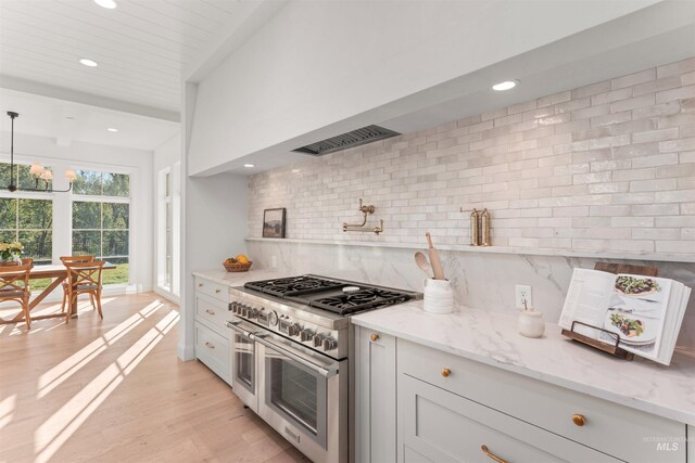 1734 S S Riparian Way, Eagle, ID 83616 - kitchen with range with two ovens, backsplash, recessed lighting, light stone counters, and light wood-style flooring
