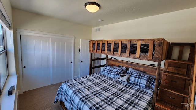 bedroom featuring a closet and dark colored carpet