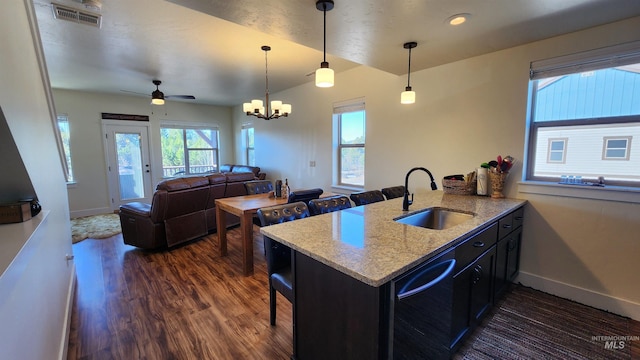 kitchen featuring decorative light fixtures, ceiling fan with notable chandelier, dark wood-type flooring, kitchen peninsula, and sink