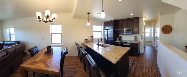 kitchen with appliances with stainless steel finishes, sink, pendant lighting, and backsplash