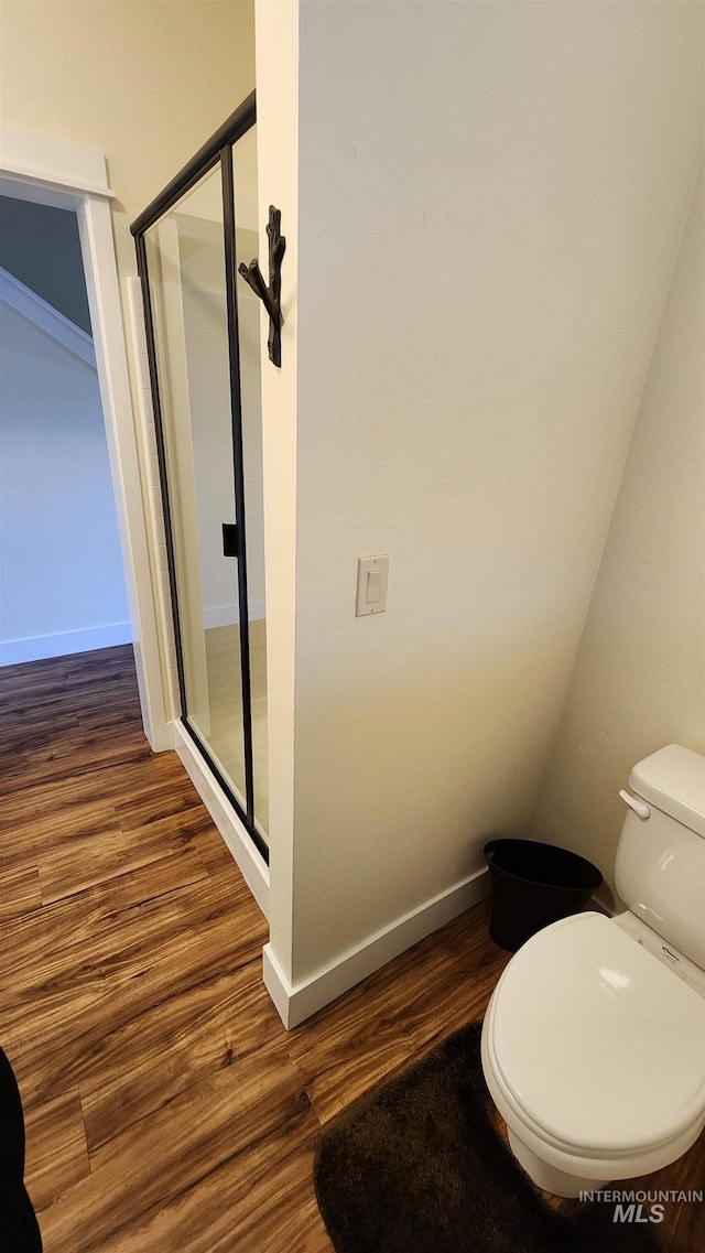 bathroom featuring an enclosed shower, hardwood / wood-style flooring, and toilet