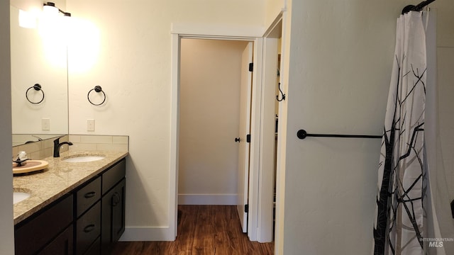 bathroom with hardwood / wood-style floors and dual vanity