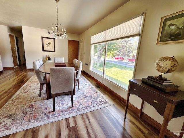 600 N 9th E, Mountain Home, ID 83647 - dining space with a chandelier, wood finished floors, and baseboards