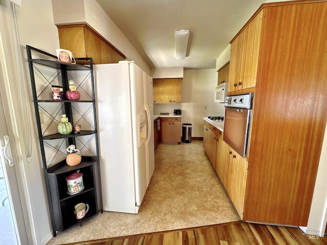 600 N 9th E, Mountain Home, ID 83647 - kitchen featuring white appliances, light flooring, light countertops, and brown cabinetry