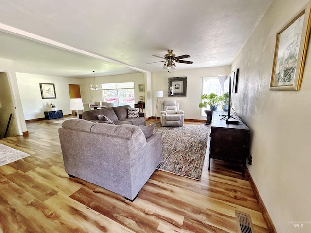 600 N 9th E, Mountain Home, ID 83647 - living room with light wood-style floors, plenty of natural light, and a chandelier