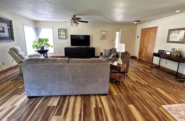 600 N 9th E, Mountain Home, ID 83647 - living room featuring wood finished floors, healthy amount of natural light, baseboards, and ceiling fan
