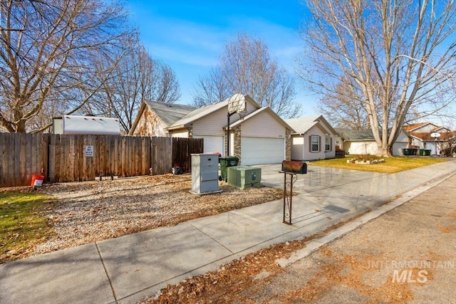 view of front facade featuring concrete driveway, brick siding, an attached garage, and fence