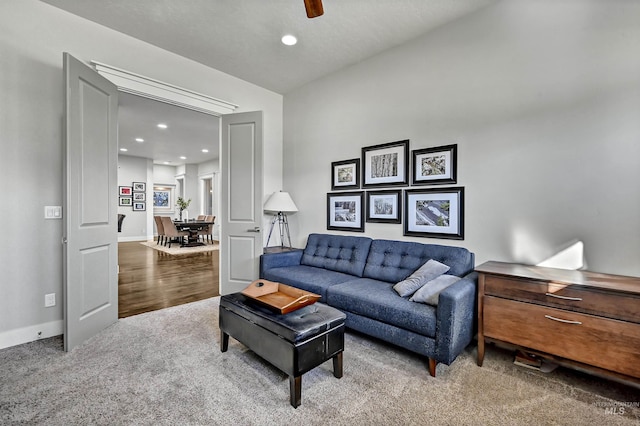 carpeted living room with ceiling fan