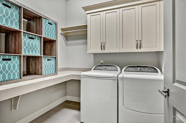 laundry room with washer and dryer, cabinets, and light tile patterned floors