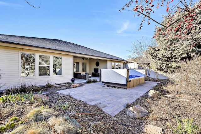 rear view of property with a patio area, a hot tub, and ceiling fan