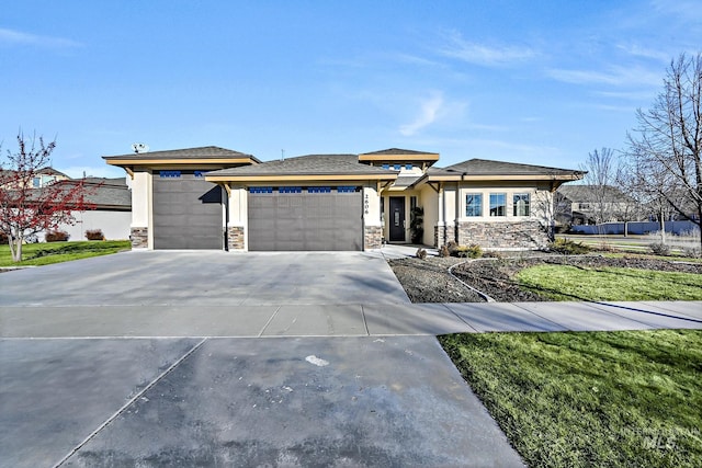 prairie-style house featuring a garage and a front yard