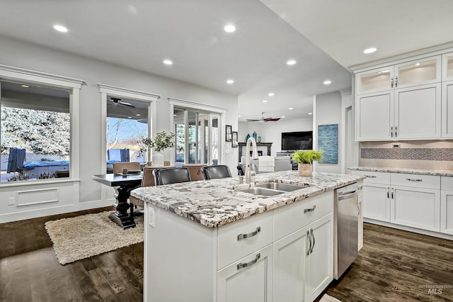 kitchen featuring a center island with sink, dark hardwood / wood-style flooring, stainless steel dishwasher, white cabinets, and sink